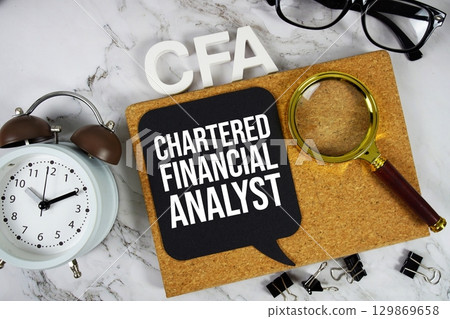 CFA Chartered Financial Analyst acronym with alarm clock and magnifying glass, Business concept background CFA Chartered Financial Analyst acronym with alarm clock and magnifying glass, Business concept background 129869658