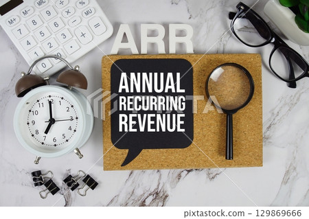 ARR Annual Recurring Revenue acronym with calculator, alarm clock and magnifying glass, Business concept background ARR Annual Recurring Revenue acronym with calculator, alarm clock and magnifying glass, Business concept background 129869666