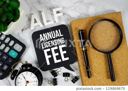 ALF Annual Licensing Fee acronym with calculator, alarm clock and magnifying glass, Business concept background 129869670
