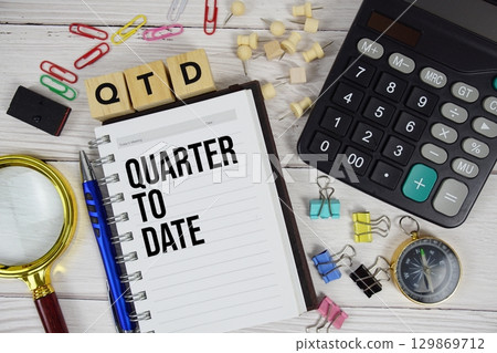 QTD Quarter To Date acronym on notepad, business and financial concept background QTD Quarter To Date acronym on notepad, business and financial concept background 129869712