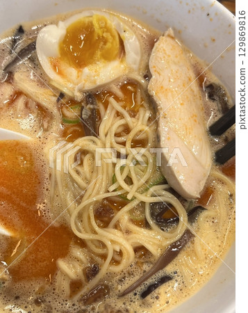 A steaming bowl of ramen with rich broth, tender noodles, sliced pork, boiled egg, nori, and fresh green onions. A comforting and flavorful Japanese classic. A steaming bowl of ramen with rich broth, tender noodles, sliced pork, boiled egg, nori, and fresh green onions. A comforting and flavorful Japanese classic. 129869816