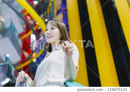 一位女士在百貨公司搭乘自動扶梯 129870120
