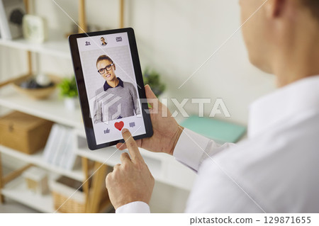 Person using smartphone dating app to like a profile with heart icon closeup Person using smartphone dating app to like a profile with heart icon closeup 129871655