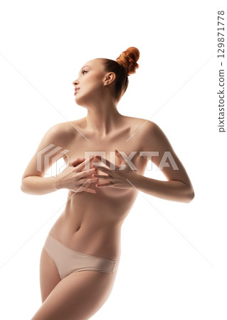 Saxy young topless lady touching torso in white studio Saxy young topless lady touching torso in white studio 129871778