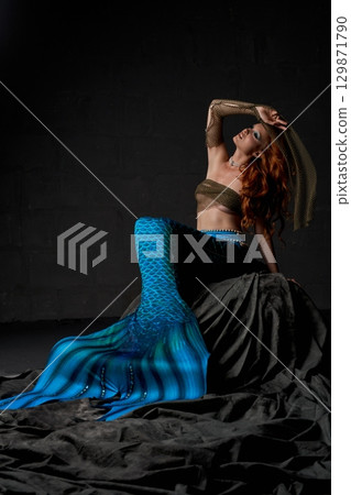 Young alluring mermaid in nets on the ocean floor 129871790