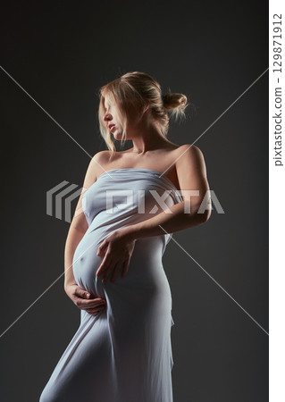 Beautiful pregnancy of young slim woman in silk 129871912
