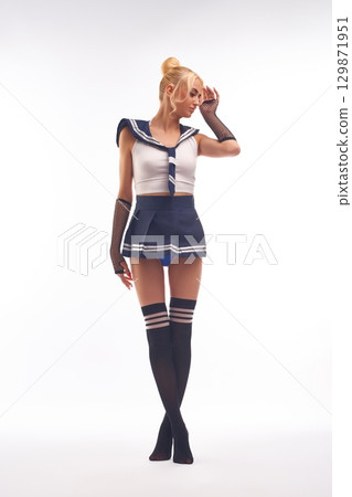 Slim alluring woman in sailor clothes standing against white background Slim alluring woman in sailor clothes standing against white background 129871951