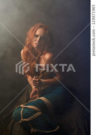 Aggressive mermaid getting out of trap in studio 129871965