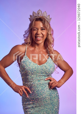 Women's bodybuilder champion in sparkly dress and crown Women's bodybuilder champion in sparkly dress and crown 129872040