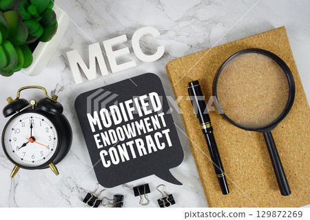 MEC Modified Endowment Contract text with alarm clock and magnifying glass on marble background MEC Modified Endowment Contract text with alarm clock and magnifying glass on marble background 129872269