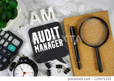 AM Audit Manager text with Calculator, alarm clock and magnifying glass on marble background 129872285