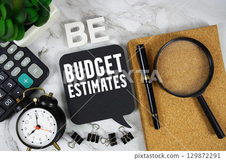 BE Budget Estimates text with Calculator, alarm clock and magnifying glass on marble background 129872291