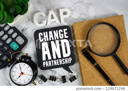 CAP Change And Partnership text with Calculator, alarm clock and magnifying glass on marble background 129872298