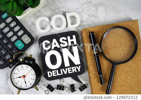 COD Cash On Delivery text with Calculator, alarm clock and magnifying glass on marble background 129872312