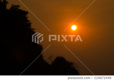 Sunset over a limestone cliff. 129872440