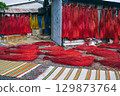 Dyed red reeds are dried at the village handicraft factory for the production of traditional Vietnamese mats in Vietnam 129873764