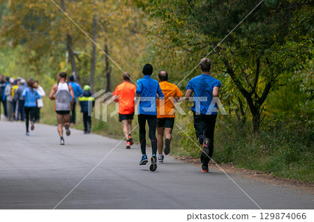 Large group runners running marathon in autumn park Large group runners running marathon in autumn park 129874066