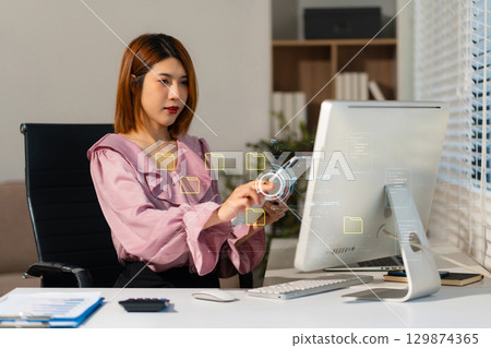 woman working on laptop computer with digital document, managing files data, paperless workflow, data search, cloud technology. 129874365