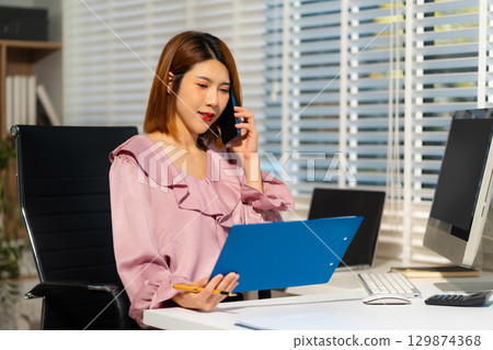 women talk mobile phones update tasks with milestones progress planning while working on laptop computers, online business, work from home, teleworking concept. 129874368