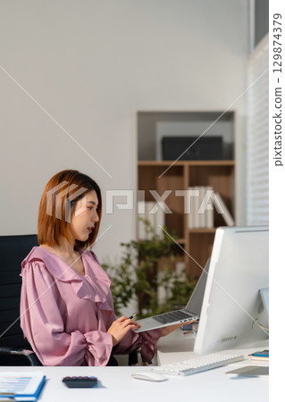 Business concepts, women working in the work area with tablet and data sheets at the desk. Business concepts, women working in the work area with tablet and data sheets at the desk. 129874379
