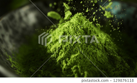 Freeze Motion Detail Shot of Sprinkling Matcha Powder 129876118