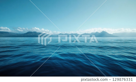 A breathtaking view of the calm deep blue ocean stretching toward distant mountains 129876331