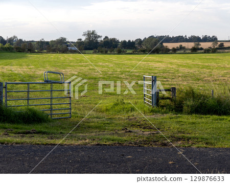 Open Field Gate at a Rural Agricultural Location on a Summer Evening 129876633