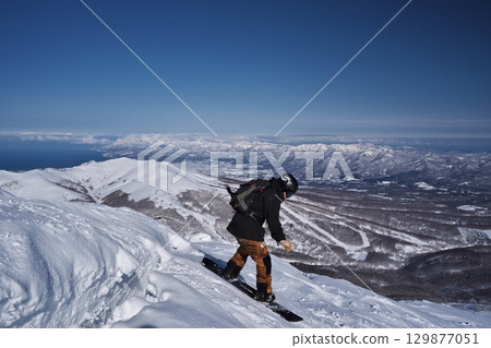 隆冬時節，滑雪者們在新雪谷安努普利山北脊的冰裂縫上跳躍 129877051