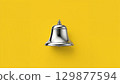 Metal bell over yellow background 129877594
