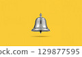 Metal bell over yellow background 129877595
