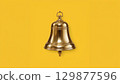 Metal bell over yellow background 129877596