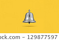 Metal bell over yellow background 129877597