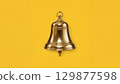 Metal bell over yellow background 129877598