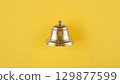 Metal bell over yellow background 129877599