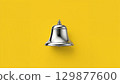 Metal bell over yellow background 129877600