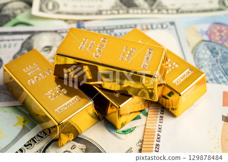 Gold bars on US dollar banknote money, finance trading investment business currency. 129878484
