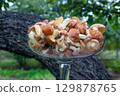 Glass Vase Filled with Suillus Mushrooms Outdoors in Garden Background 129878765