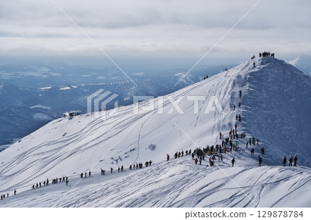 人們從位於滑雪場管理區外的新雪谷東急格蘭比羅夫滑雪場的山坡上爬上來 129878784
