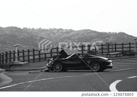 A black convertible car standing in an empty parking lot A black convertible car standing in an empty parking lot 129878805