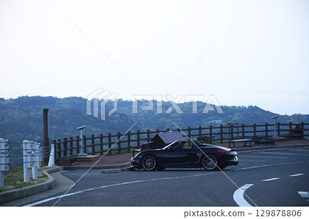 A black convertible car standing in an empty parking lot A black convertible car standing in an empty parking lot 129878806