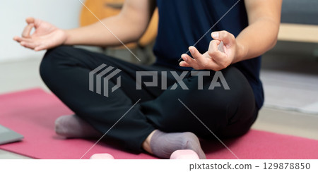Mindfulness and Wellness. Man practicing meditation with weights at home. Mindfulness and Wellness. Man practicing meditation with weights at home. 129878850