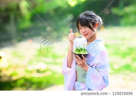 日本小學生身穿浴衣在高原湖畔吃刨冰的場景 日本小學生身穿浴衣在高原湖畔吃刨冰的場景 129878896