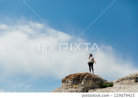 brunette looking at the landscape from the top of the mountain 129879425