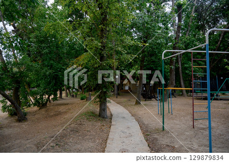 Children's playground with a view of the house and slide in the park 129879834
