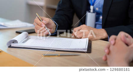 Insurance Consultation. Business professional reviewing policy documents with a client. 129880181