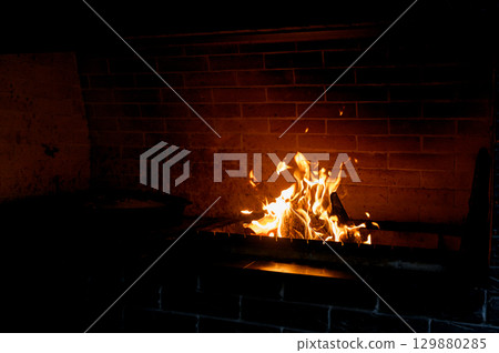 Cozy living room with a modern stone fireplace, warm flames flickering inside, creating an inviting and tranquil atmosphere. Cozy living room with a modern stone fireplace, warm flames flickering inside, creating an inviting and tranquil atmosphere. 129880285
