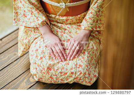 一位身著和服的女子靜靜地站在陽台上 129880797