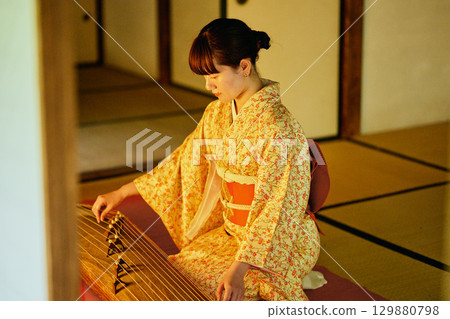 一位身著和服的女子正在彈奏古箏 129880798