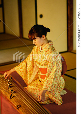 A woman in a kimono playing the koto 129880799