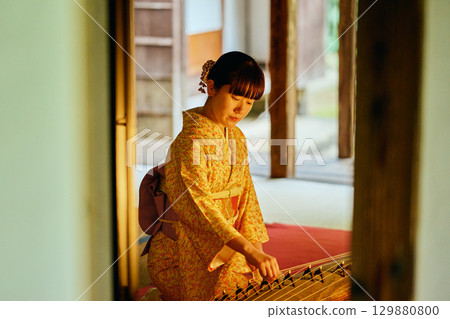 A woman in a kimono playing the koto A woman in a kimono playing the koto 129880800